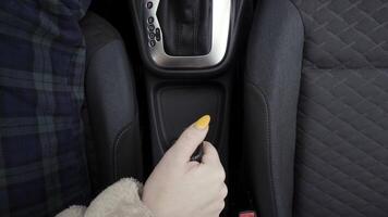 Driver woman controlling automobile and pulling handbrake. Action. Close up top view of female hand raising handbrake and loosing it. video