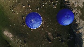 top visie van twee kleurrijk heet lucht ballon in de platteland Oppervlakte. schot. aerostaat vlucht over- velden en stenen, concept van avontuur. video