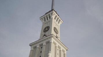 Bottom view of a clock tower with a long spire on blue cloudy sky background. Action. Details of an ancient historical building. video