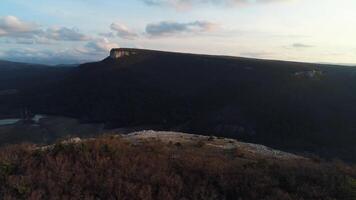 antenne visie over- verbazingwekkend rotsen en de zonsopkomst. schot. adembenemend landschap met steen kliffen en de duidelijk ver in de afstand. video