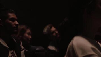 Group of students watching documentary in a dark classroom. Stock footage. Men and women watching and discussing a lecture. video