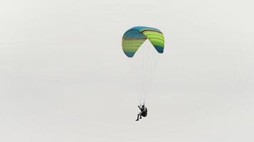 extremo esporte conceito, parapente planador através a ar dentro a céu. Ação. paraquedista subindo em nublado céu fundo. video