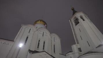 Unterseite Aussicht von ein groß und schön Weiß Kirche mit Gold Kuppel. Lager Filmaufnahme. Tempel auf Nacht Himmel Hintergrund, Konzept von Vertrauen und Religion. video