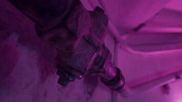 Close up of leaky faucet pipe under the blinking pink and green lights. Stock footage. Concept of a party in poor neighborhood, dripping water from plumbing. video