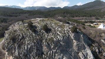 un degno di nota aereo Visualizza di un' gruppo di alto rocce nel estate. sparo. naturale paesaggio con selvaggio roccia formazioni coperto di verde impianti con montagnoso valle su il sfondo. video