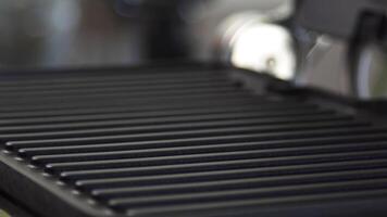 Close up of small grill grate for home barbeque cooking on blurred background. Household utensils. Details of a modern kitchen interior. video