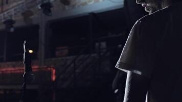 A young guy stands on the stage and looks down in silence, theater rehearsal. . Rear view of an actor standing on a stage in front of empty hall. video