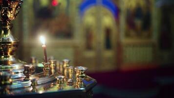 Prayer candles. Candle holder in the Russian Orthodox Christian Church. . Church candles in sand candlesticks on Icons background in empty interior, religious rites of Christianity video