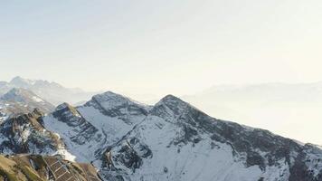 mozzafiato aereo Visualizza di un' gelido mattina nel montagnoso valle. hdr. bellissimo appuntito montagna picchi nel un' mattina foschia e luce del sole . video