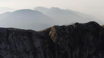 Aerial view of majestic mountains covered by thick fog early in the morning under the sun rays. HDR. Flying above calm beautiful hills. video