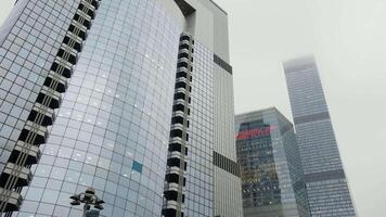 Bottom view of various international business centers, modern architecture. Action. Skyscrapers in Financial District of a big city on heavy sky background. video