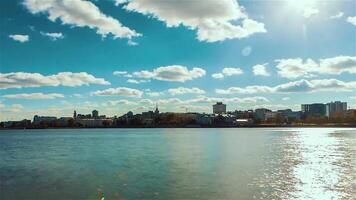 magnifique paysage avec une écoulement rivière et le bleu nuageux ciel réfléchi dans l'eau surface avec une ville sur le Contexte. . laps de temps effet de une ville situé le long de le rivière. video