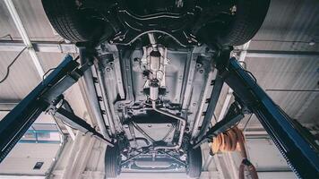 View under the car at the service station. . Bottom view of a car car suspension at the service center, car maintenance. video