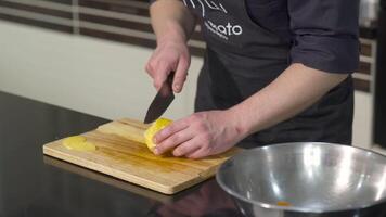 detailopname van chef snijdend geheel oranje. kunst. koken bezuinigingen oranje in plakjes in ongebruikelijk manier. ongebruikelijk manier van snijden oranje video