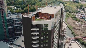 aérien vue de une Nouveau moderne multi étage bâtiment de affaires classe avec une terrasse et vert herbe sur le toit. . construction site de une Nouveau Résidentiel complexe. video