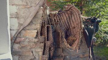 Rustic rural concept, antique handmade traditional russian bast shoes. . Pairs of bast shoes hanging on the old brick house wall, old fashioned products of birch bark. video