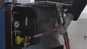 Professional equipment at the car repair center. Scene. Close up of man hands using inflate compressor and and air pressure hose. video