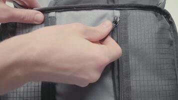 Hand closes gray bag. Action. Close-up of hand closes lock of small gray bag. Simple grey bag for small items video