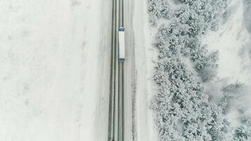 Antenne Schuss von schneebedeckt Straße im das Landschaft Karpaten Berge mit Auto auf Weg. scannen. rutschig Winter Land Straße mit Brücke über gefroren Fluss. Karelien, Russland. Fahrzeuge Fahren auf video