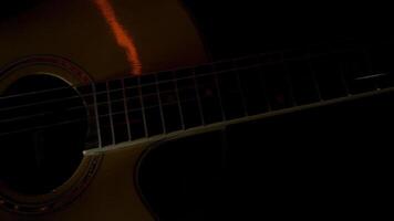 homem jogando acústico guitarra dentro uma Sombrio sala, conceito do música e criatividade. hdr. fechar acima Visão do masculino dedos jogando ritmo só com uma mediador. video