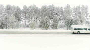 antenn skott av snötäckt väg i de landsbygden karpater bergen med bil på sätt. skanna. hal vinter- Land väg med bro tvärs över frysta flod. karelen, Ryssland. fordon körning på video