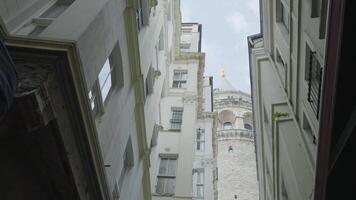 Galata Tower with residential buildings. Action. View from below of medieval tower in center of old residential town. Residential buildings near Galata Tower in Istanbul video