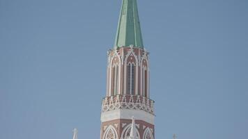 Nikolskaya tower of Moscow kremlin. Action. Bottom view of historic red brick tower on background of blue sky. Beautiful tower on Red Square in Russia video