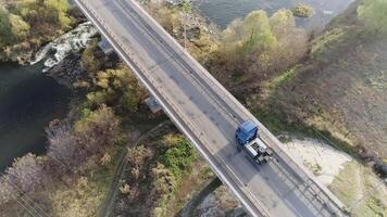 antenne visie van vrachtauto het rijden door de brug bovenstaand de meer. tafereel. snelweg uitwisseling met verkeer. video