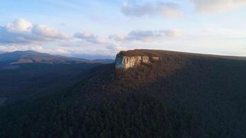 schön Berg Panorama mit Felsen und Kreuz. Schuss. oben Aussicht von heilig Felsen mit Kreuz auf Hintergrund von Grün Berge. Sonne scheint auf Single Felsen mit Kreuz video