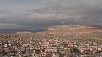 Aerial panoramic view of a southern city under bright hot sun on a summer day. Action. Many small houses and narrow streets on dry mountains on the background. video