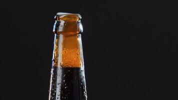 Close up of a hand opening a glass bottle. . Alcoholic drink isolated on black background, concept of party. video