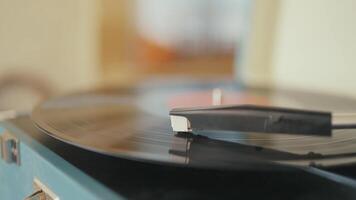 Vinyl record player with the needle on the rotating plate. Action. Close up of working retro vinyl player on home interior background. video