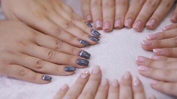 fechar acima do fêmea mãos em branco mesa superfície fundo. . demonstração do Novo manicure, francês e listrado Projeto. video