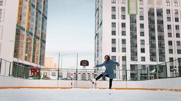 professionell kvinna is figur skater praktiserande spinning på utomhus- skridskoåkning rink. . kvinna is dans omgiven förbi bostads- hög stiga hus. video