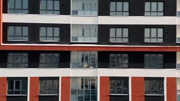 aéreo ver de nuevo moderno, vistoso, alto subir edificio, concepto de urbanización y arquitectura. . naranja y negro multi piso residencial casa. video