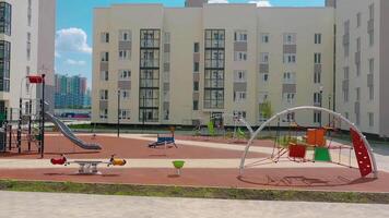 A modern playground is empty in the new modern residential complex. . Beautiful yard outdoors on a summer sunny day. video