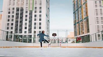 Professional female ice figure skater practicing spinning on outdoor skating rink. . Woman ice dancing surrounded by residential high rise houses. video