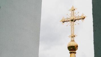 Religion and faith concept, bottom view of a golden cross of the church. . Big golden cross on cloudy sky background. video