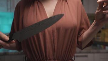 Close up of woman hands taking off a plastic tip from a steel knife at the kitchen at home. Action. Female holding a new sharp polished steel knife, concept of cooking. video