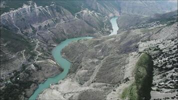 eng Berg Fluss fließend durch felsig Landschaft. Aktion. Antenne Aussicht von ein Türkis Ruhe Fluss Dehnen entlang Berg Angebot im ein Morgen Nebel. video