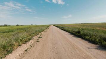 Haut vue de rural route près agricole des champs. tir. drone mouches plus de champ route sur Contexte de horizon avec bleu ciel. magnifique paysage avec route et vert des champs sur ensoleillé journée video