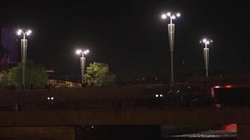 The dam of the Ekaterinburg city with lanterns and the Iset River, Russia. Stock footage. A bridge above the rive at night on black sky background. video