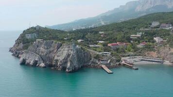 hermosa bahía con azul agua y antiguo ciudad. acción. parte superior ver de hermosa bahía con playa pueblo y escarpado acantilados hermosa costa a sur de Crimea video