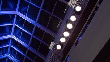 Bottom view of a glass ceiling with blue illumination and a row of shining spotlights. . Details of a hall architecture. video