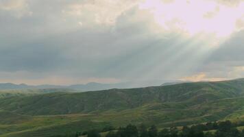 Haut vue de magnifique vert montagnes et collines dans nuageux temps avec Soleil. tir. Montagne paysage avec vert collines sur Contexte de nuageux ciel et Soleil. été vert montagnes avec herbes video