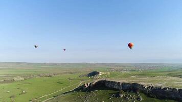 heiß Luft Luftballons im das Himmel Über das Feld im das Landschaft. Schuss. Antenne Aussicht von Aerostaten fliegen über das Sommer- Wiese. video