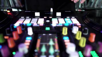 deejay giocando elettronico musica su piatto con colorato pulsanti, tempo periodo effetto. arte. dj toccante vinile, cursori a il notte club. video