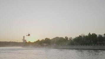 porter secours hélicoptère plus de ville. action. hélicoptère mouches plus de ville canal sur Contexte de le coucher du soleil. porter secours hélicoptère plus de ville canal avec flottant bateaux video