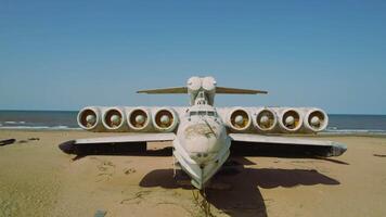 Old plane on beach. Action. Military plane landed on coast of sea many years ago. Abandoned military plane on seashore with history video