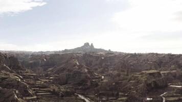 Aerial view of old Cappadocia Park in Turkey. Action. Stone houses and buildings surrounded by rocks on cloudy sky background. video